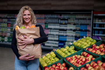 Woman in a supermarket holding paper bag while grocery shopping