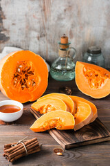 Pieces with ripe pumpkin seeds on a cutting board on a wooden table. Vegetarian food. Rustic style. Vertical view