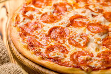 Pepperoni pizza on wooden table macro close up, selective focus