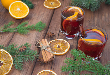Obraz na płótnie Canvas Christmas mulled red wine with spices and fruits on a wooden rustic table. Traditional hot drink at Christmas time