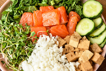 Tasty poke bowl with salmon on table, closeup