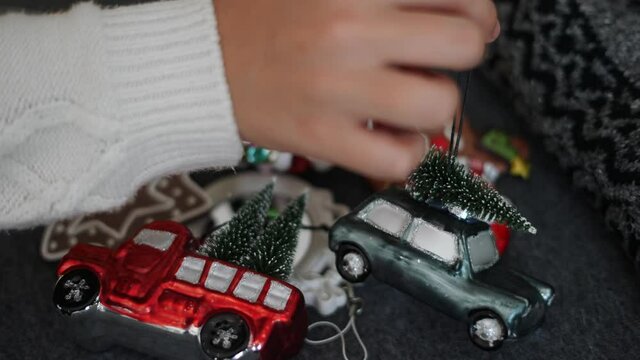 A hand choosing a vintage Christmas tree ornament in preparation for Christmas Eve and New Years Eve.