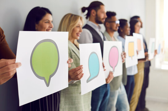 Different multiracial people holding cards and sheets of paper with pictures of various colorful mockup speech bubbles and chat message icons. Sharing opinions via messengers and social media concept