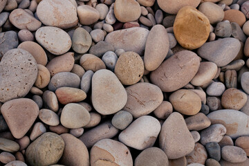 Top view of pebble stones on the beach. Rock texture wallpaper 