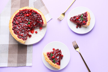 Plates with delicious lingonberry pie on color background