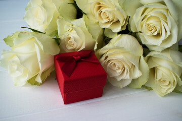 bouquet of white roses and a gift for congratulations