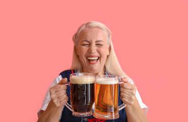 Adorable Oktoberfest woman laughing with beer mugs on pink background