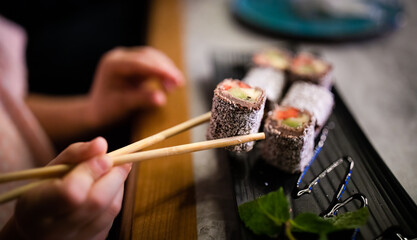 Obscured person eating Japanese dessert with chopsticks in restaurant 