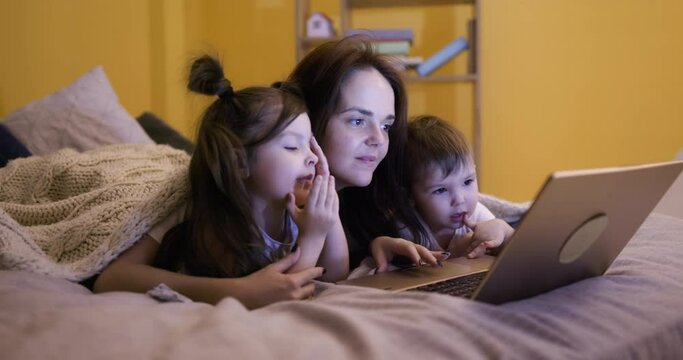 Mother and kids watching movie on laptop