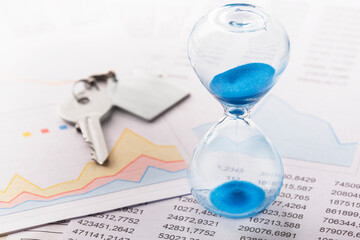 Real  estate concept - hourglass, key and calculator. Best time for investment.