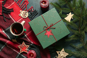 Christmas composition with gift box, cup of tea and fir branches on black background