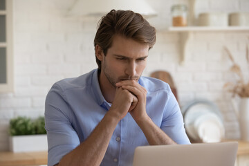 Close up serious thoughtful man faced the challenge thinks over solution, put chin on hands staring...