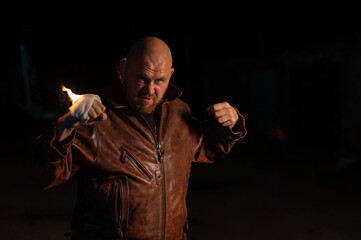 Bald Caucasian man beats with a burning fist.