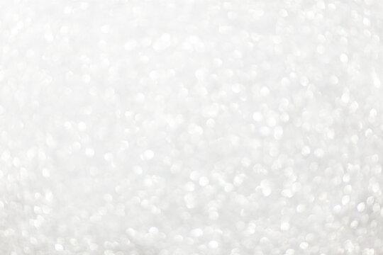 Defocused christmas or party, grey glitter background with bokeh. Holiday glowing backdrop,banner or card.