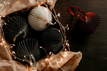 Scandinavian christmas paper ornaments in the box over wooden background. Modern christmas...