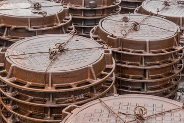 Old rusty manholes are packed and stored outdoors