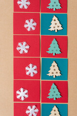 white fabric snowflake shapes on paper squares with wooden ornament christmas trees