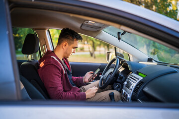 Side view of young caucasian man checking mobile phone for messages or navigation app for...