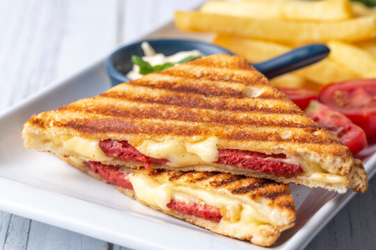 Turkish toast, mixed toast with cheddar cheese, sausage and ham, with fried potatoes (Turkish name; Karisik tost)