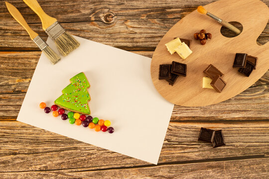 Assorted chocolates are set on an artistic palette against a warm wooden background.