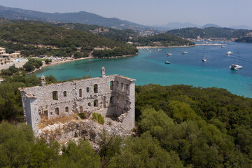 Aerial shot of derelict house on mountain by the beach of Valtos in Parga Greece
