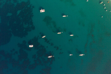 Aerial shot of moored sailing boats on turquoise sea of Valtos beach at Parga Greece
