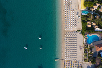 Aerial shot of moored sailing boats and umbrellas at organized beach of Valtos beach at Parga Greece