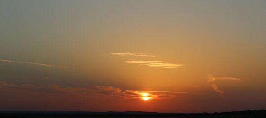 Fototapeta premium Bright orange sunrise coming over the hills and valley floor in West Texas