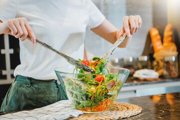 Vegetarian woman mixing vegetable Pour sauce on the salad dish while cooking in kitchen