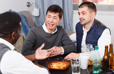 Friendly meeting and discussion in men company at table at home