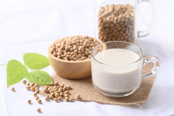 Soy milk in a cup glass and soy beans in a bowl on white background, Healthy drink