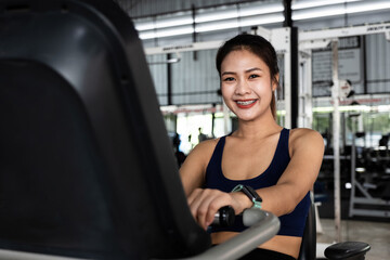 A portrait of asian young girl or woman doing cardio workout in a gym.