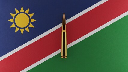 Fototapeta premium 3D rendering of top down view of a single rifle bullet in the center and on top of the national flag of Namibia
