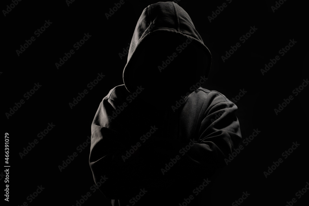Poster man without a face in a hood on a dark background.