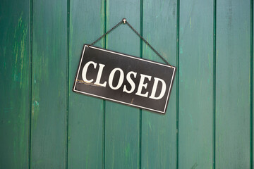 Closed Sign on a door, black iron sign with white lettering
