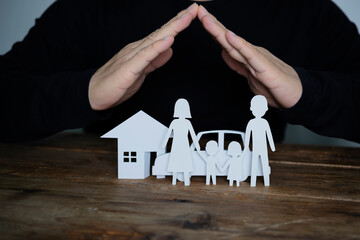 Fototapeta na wymiar Concept of insurance with hands over a house, a car and a family