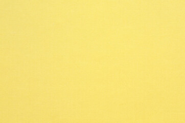 Natural yellow-dyed fabric texture background. Close-up of soft cloth backdrop.