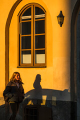 Stockholm, Sweden  A woman walks on the sidewalk on Eriksbergsgatan in the rich autumn sun.