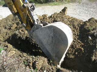 
excavator bucket digs the ground