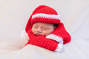 Cute Newborn baby wearing santa costume lying and sleep waiting for celebrate merry christmas and happy new year.Calm of infant baby sleep with red santa cloth