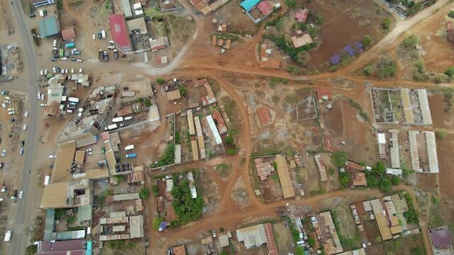 Aerial view of a town and sunlit fields, golden hour in rural Africa - tracking, drone shot. Green bio organic low waste smart agriculture. climate change Paris agreement. Rural Africa village-kenya