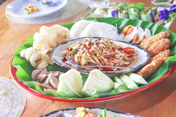 Spicy papaya salad with bean,egg , thai rice flour noodles, pork snack, in tray ,Thai food background