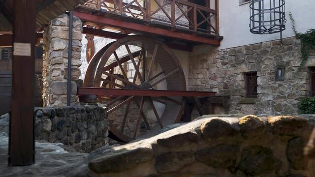 Old wooden watermill wheel in a castle courtyard in sunlight,Czechia.