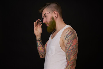 bearded man in white t-shirt with tattoos on his arms posing bully