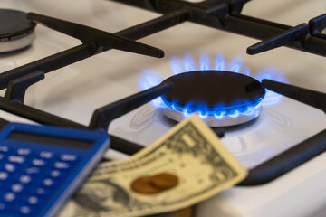 Shortage and gas crisis. Money and a calculator on the background of a burning  gas stove