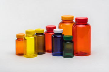 Multi colored transparent plastic pill jars on a white background. Isolated