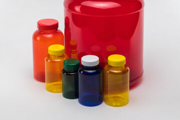 Multi colored transparent plastic pill jars on a white background. Isolated