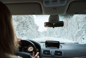 Woman driver on winter snowy road. Car move on slippery road, dangerous driving