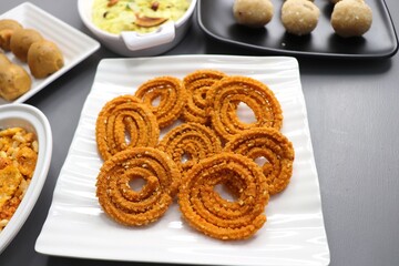 Indian festival food - Diwali Special sweet and salty snacks such as Chakli, Rava laddu, besan ladu, poha chivda, and corn mixture, Namkeen snacks. Diwali Faral from Maharashtra, India. Copy space.