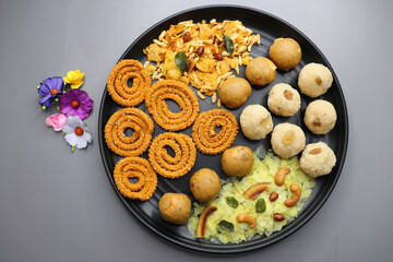Indian festival food - Diwali Special sweet and salty snacks such as Chakli, Rava laddu, besan ladu, poha chivda, and corn mixture, Namkeen snacks. Diwali Faral from Maharashtra, India. Copy space.